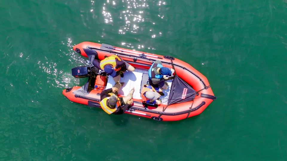 Tripulación en bote rojo vista desde arriba