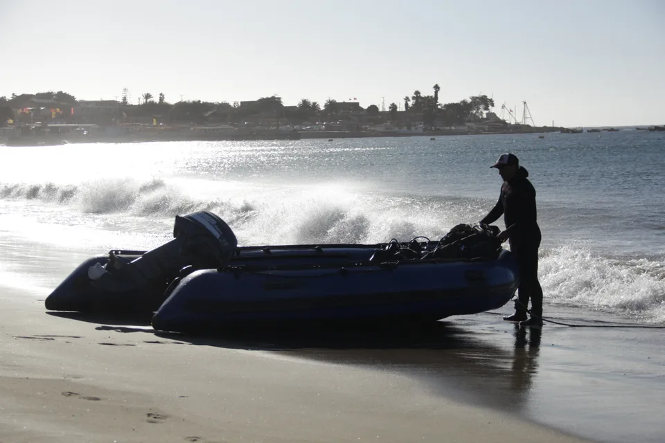 Bote azul navegando cerca de la playa